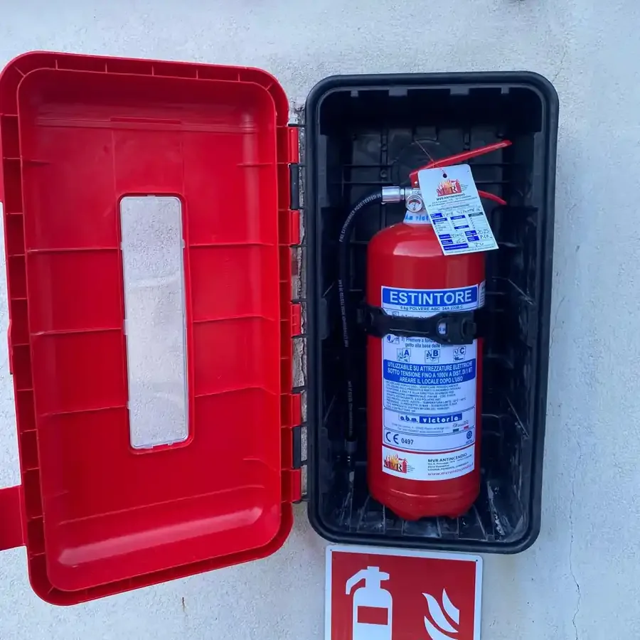 Cassetta con estintore installata all'esterno di una struttura ricettiva, con segnaletica